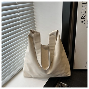 Detailed side view of a cream minimalist tote bag with smooth matte PU leather texture
