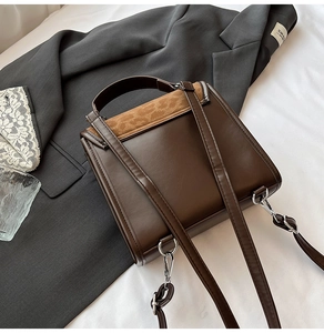 Detail of vintage patchwork handbag featuring brown matte leather and silver metal buckles