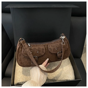 Detail of dark brown faux suede shoulder bag with dual pockets and silver buckles