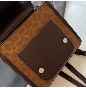 Detail of brown leopard print texture and magnetic buckle on stylish women's shoulder bag