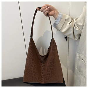Detail of vintage leopard print tote bag with soft suede texture held by hand