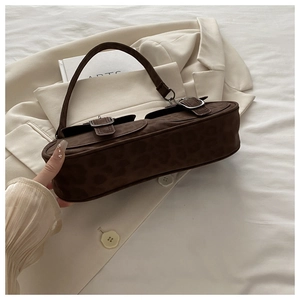Detailaufnahme einer braunen Schultertasche mit Leopardenmuster und Silberschnallen