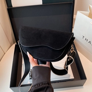 Fashionable black matte saddle bag with wide patterned strap and embossed fashion text