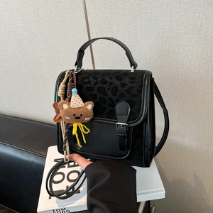 Fashionable black crossbody bag with leopard print lid and cute brown bear pendant