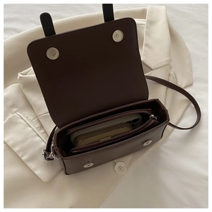 Detailed interior of the brown crossbody bag showing main compartment and zipper pocket