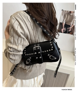 Détail du sac bandoulière en similicuir noir avec rivets argentés et boucles punk