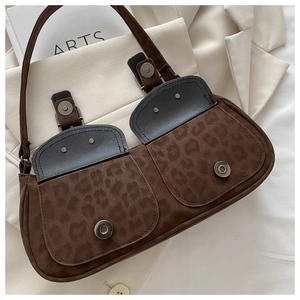 Macro view of leopard print shoulder bag with dual buckle pockets and suede texture