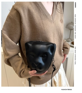 Sac bandoulière tendance en forme de tête de léopard noir porté par un mannequin