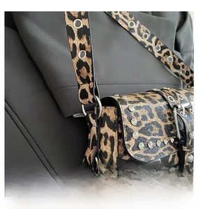 Close-up of metal rivets and reinforced hardware on leopard print motorcycle bag