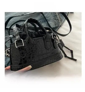 Détail du sac à main noir à texture crocodile avec doublure et doubles poignées