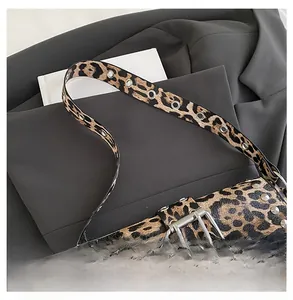 Detailed close-up of leopard print shoulder bag with silver studs and eyelet strap