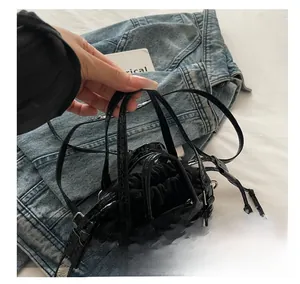 Détail de la texture croco et de la pochette intérieure à cordon sur le sac seau