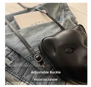 Gros plan du sac bandoulière 3D avec boucle de bandoulière réglable et design face