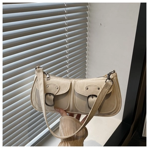 Detail view of cream underarm bag with double buckle pockets and zipper closure