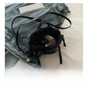 Vue détaillée du sac seau noir motif crocodile montrant sa capacité de rangement
