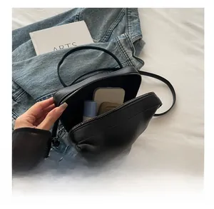 Vue intérieure montrant la grande capacité du sac bandoulière noir pour les essentiels