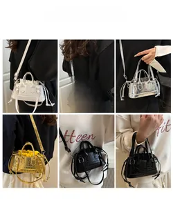 Detail of crocodile embossed mini bucket bags in white, silver, gold, and black finishes