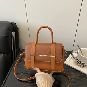 Classic caramel brown leather crossbody bag with top handle and gold metal hardware