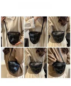 Vue détaillée du grand sac bandoulière noir avec relief facial 3D et sangle ajustable