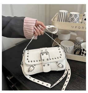 Détail du sac à main blanc avec rivets argentés et boucle en métal chromé