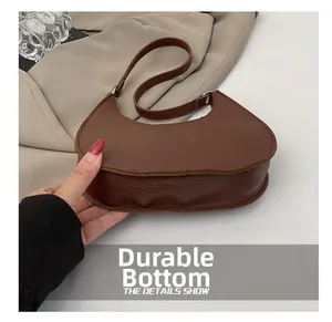 Detail of durable base and lychee texture on brown hobo bag with smooth stitching