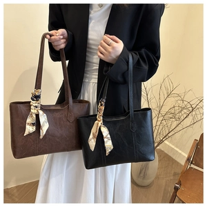 Detail von Vintage-Tragetaschen mit strukturiertem Kunstleder und dekorativen Seidenschals
