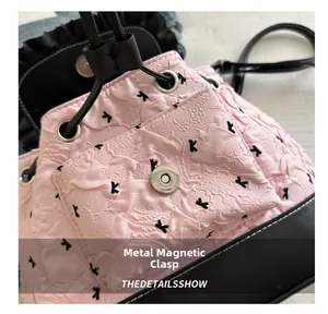 Detail of pink backpack with bow print featuring a metallic magnetic buckle closure
