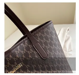 Macro detail of the brown tote bag with letter print and premium gold hardware finish