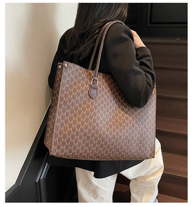 Detailed view of the large tote bag showing M-letter prints and brown shoulder straps