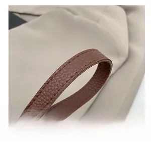 Close-up of brown litchi pattern leather shoulder strap with neat stitching details