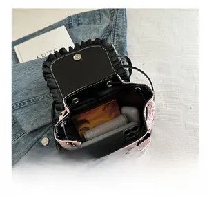 Pink quilted backpack showing interior capacity for phone, earbuds and cosmetics