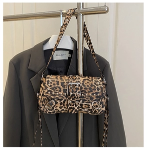 Close-up of leopard print crossbody bag featuring silver studs and wide shoulder strap