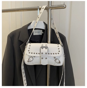 Detail of white studded crossbody bag showing silver rivets and metallic hardware accents