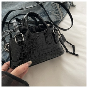 Close-up of black crocodile pattern bag with drawstring closure and fashion stamp