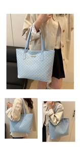 Detail of light blue monogram tote bag with golden logo plate and long shoulder strap