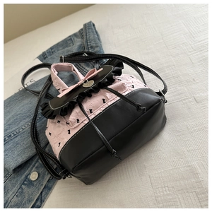 Détail du nœud rose et du pendentif cœur sur un sac à dos stylé en cuir PU
