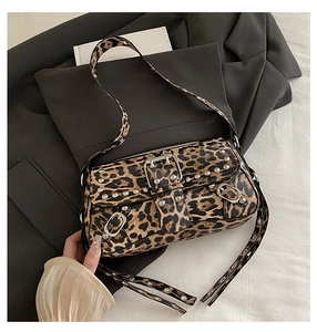 Détail du sac léopard avec clous argentés et bandoulière réglable à œillets métalliques