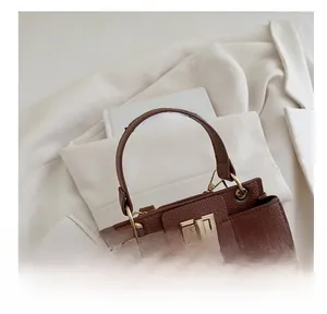Detail of lychee pattern leather handbag with gold metal clasp on a blazer