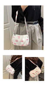 Detail of floral shoulder bag with pink roses and bow print with secure zipper closure
