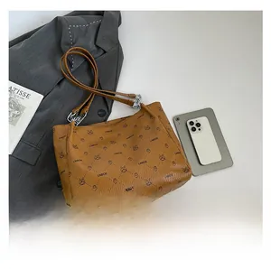 Detail of tan leather tote bag featuring bear print and brand letter patterns