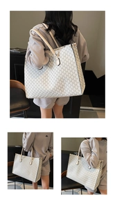 Detailed view of beige tote bag with black M-letter print and slim shoulder straps