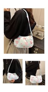 Close-up of light blue floral underarm bag with pink rose and bow prints on nylon fabric