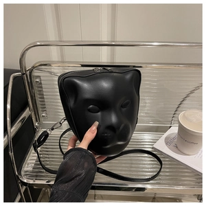 Close-up of a 3D leopard head crossbody bag in matte black leather with metal zipper