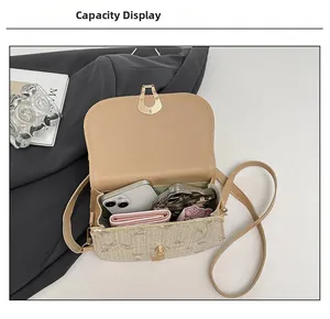Internal capacity of beige straw crossbody bag with floral embroidery and gold buckle