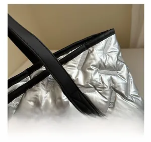 Detail of silver quilted tote bag showing high-quality stitching and black leather strap