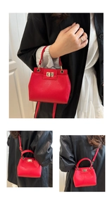 Detail of red litchi texture leather handbag with gold metal clasp and adjustable strap