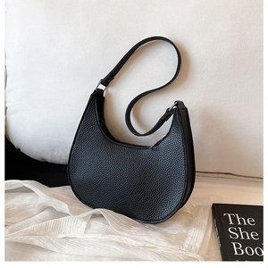 Detailed macro view of the black lychee-textured leather on this chic crescent bag