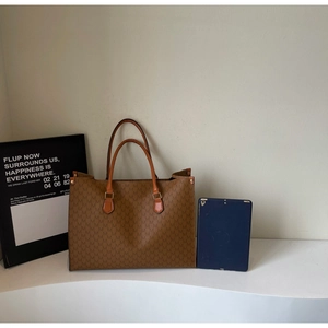 Detailed view of caramel tote bag with M-pattern print showing large interior capacity