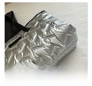 Detail of silver quilted tote bag showing precision stitching and metallic texture