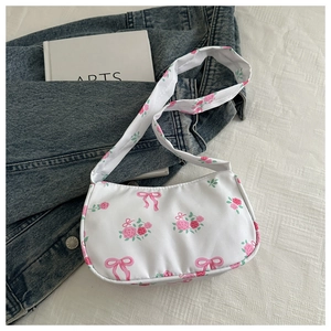 Close-up of crescent canvas bag with pink rose patterns and bow decorations